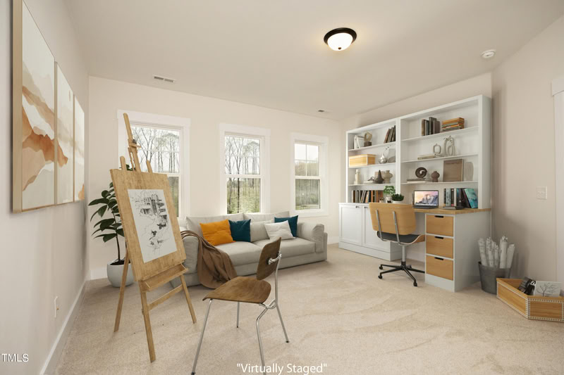 A bright, carpeted bonus room with three windows, off-white walls, and a large white built-in bookshelf and desk unit.